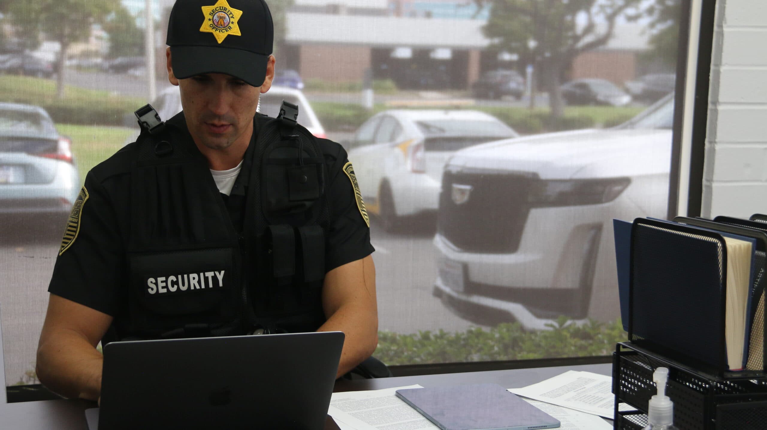 A dispatch team reviews security guard activity on a laptop using guard management software.