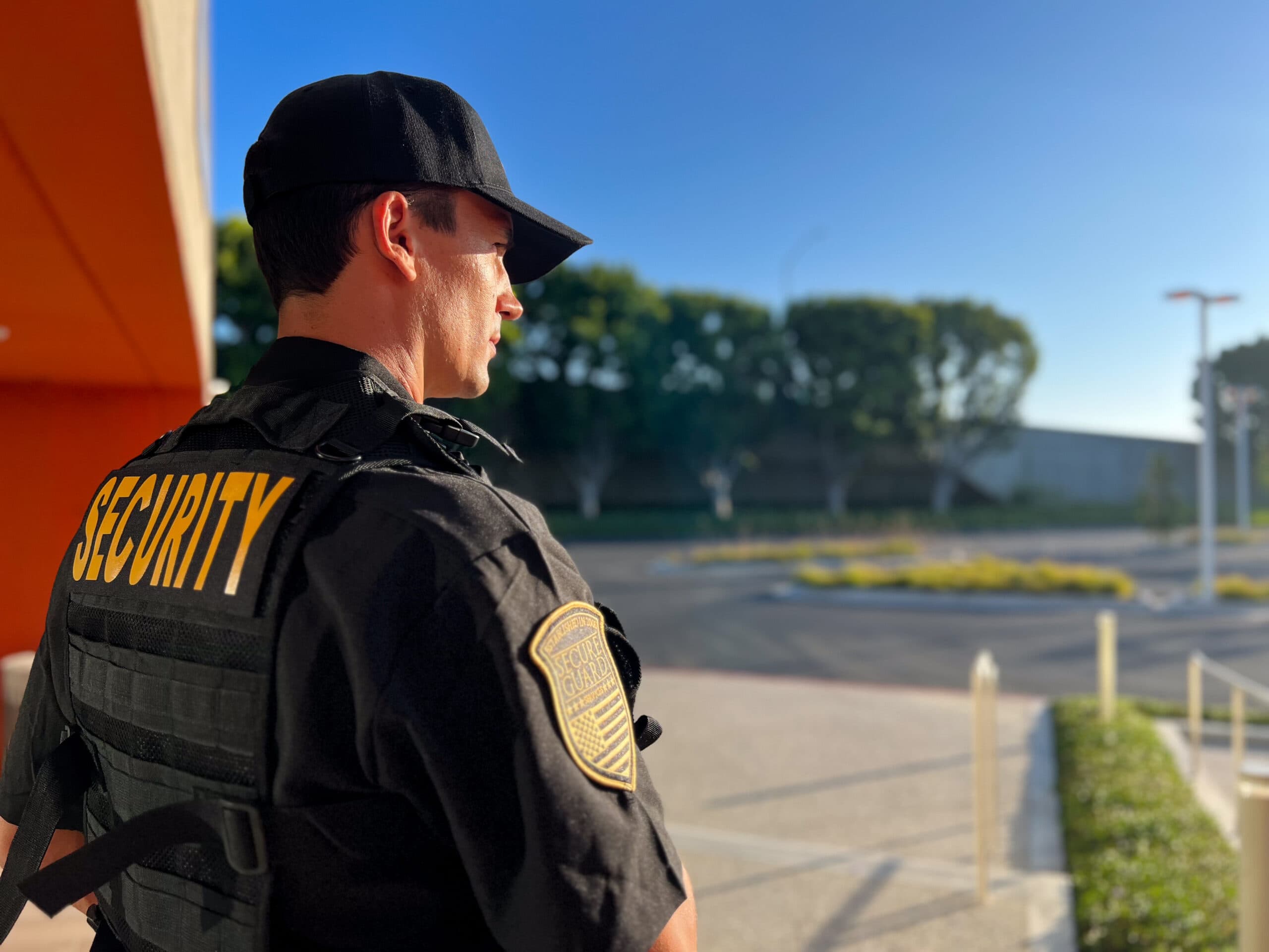 A professional security guard monitoring a commercial property in Los Angeles during daylight, ensuring safety and protection.