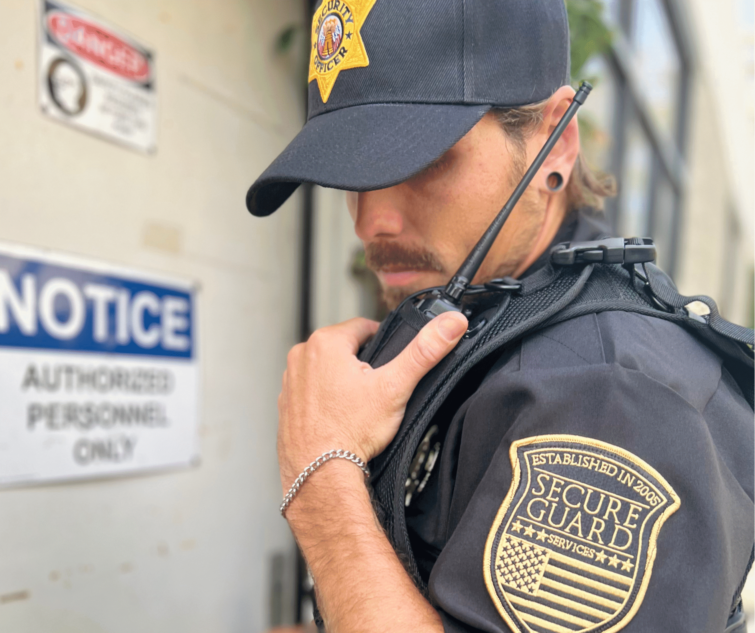 A professional security guard using a radio while monitoring a restricted area, representing how AI technology is enhancing modern security guard services.