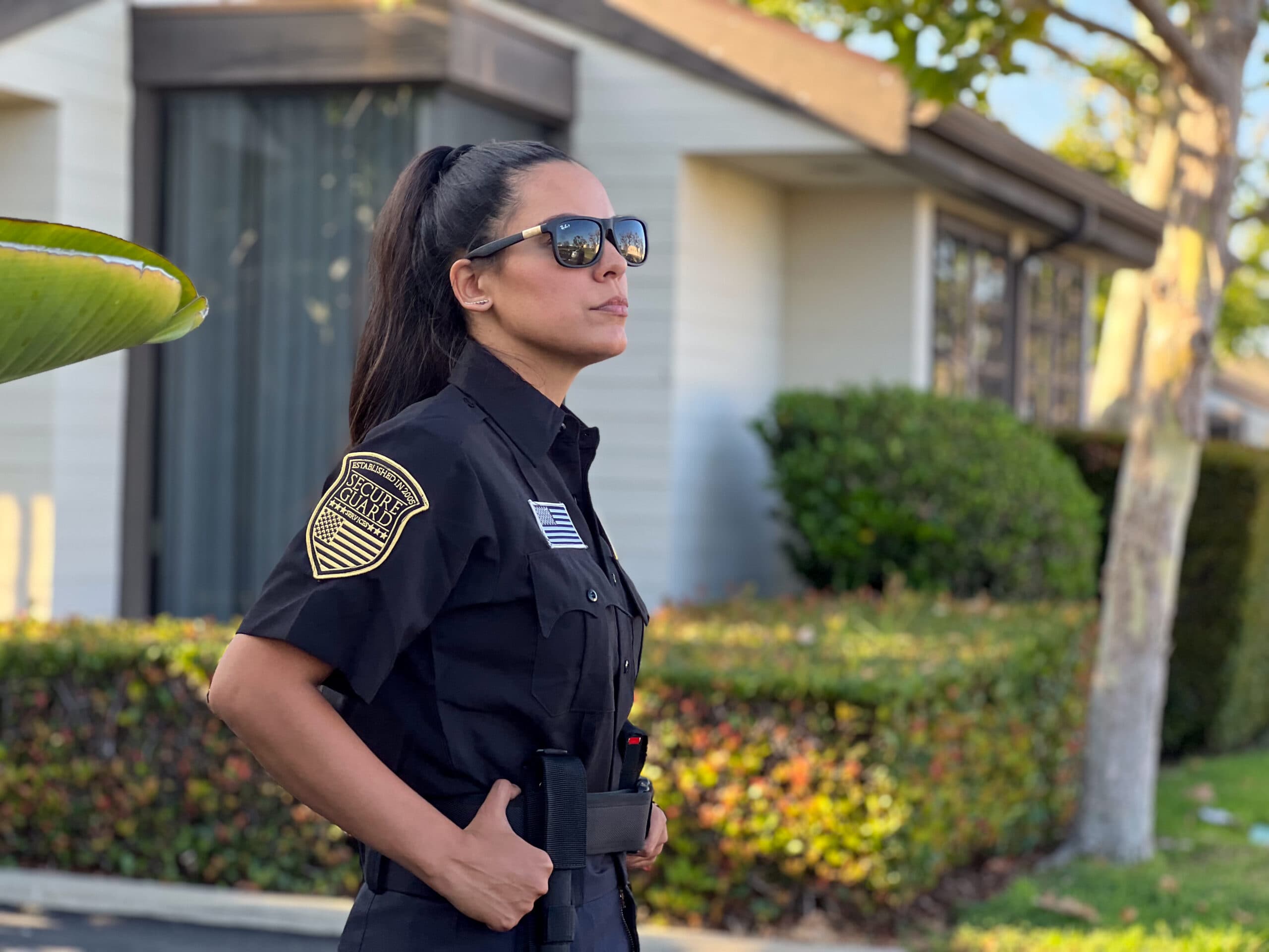 Professional female security guard on patrol outside residential property in California, ensuring community safety and protection.