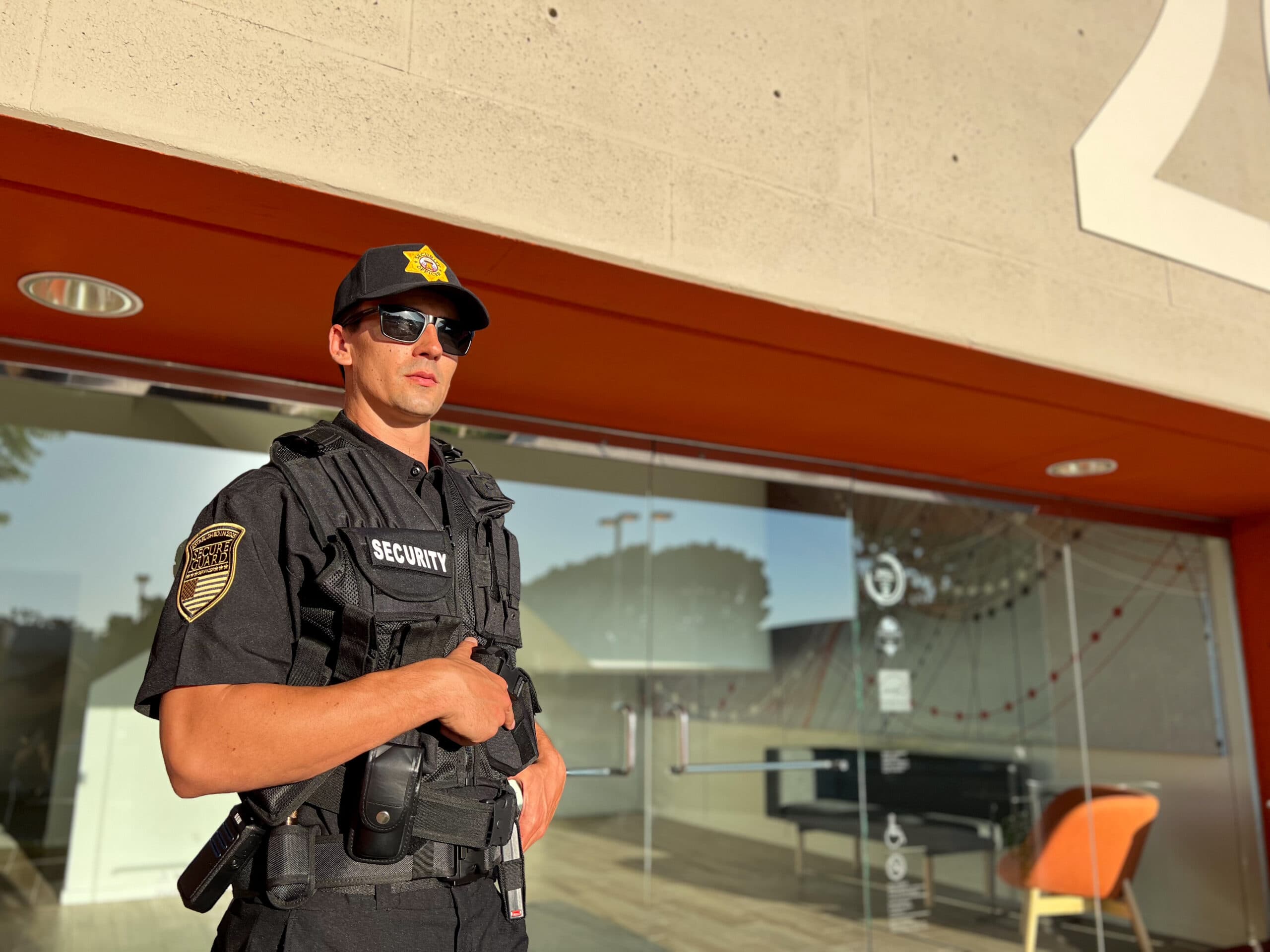Uniformed security guard standing outside a hotel entrance in California, providing professional protection for guests and staff.