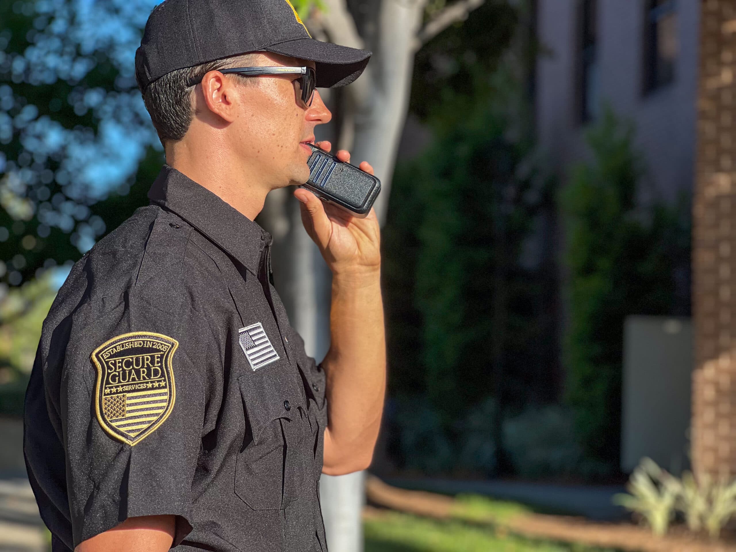 Professional security guard communicating via radio while providing apartment HOA security services in Stockton communities.