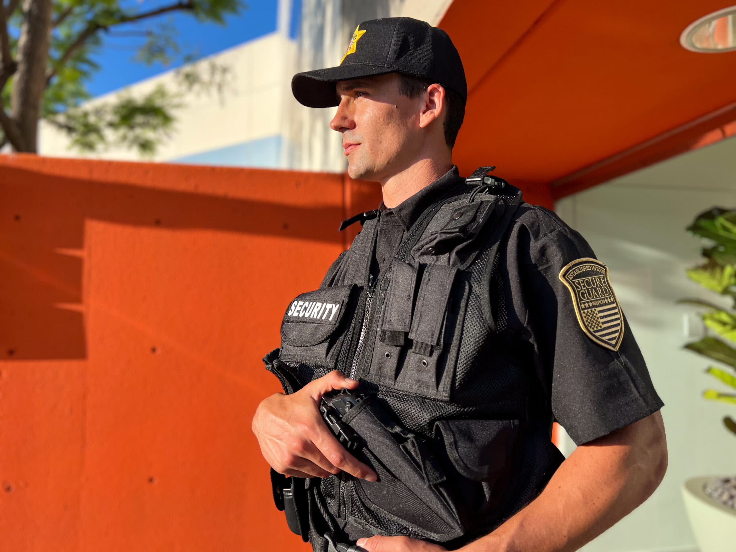 Armed professional security guard stationed outside a modern office building in Los Angeles, showcasing proactive office building security strategies and licensed onsite protection services across LA and the Bay Area.