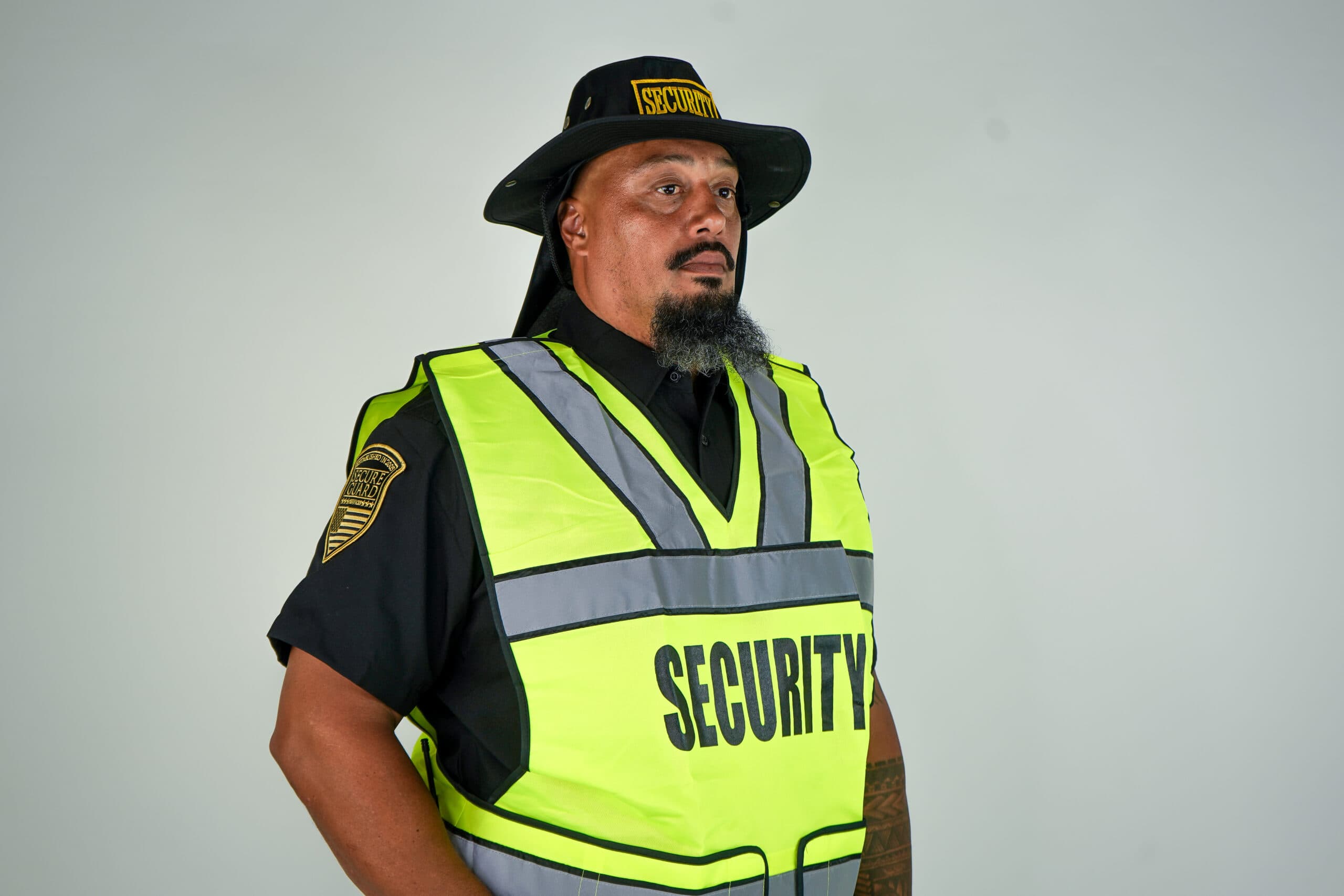 Construction site security guard in high-visibility vest providing equipment and property protection services in Riverside