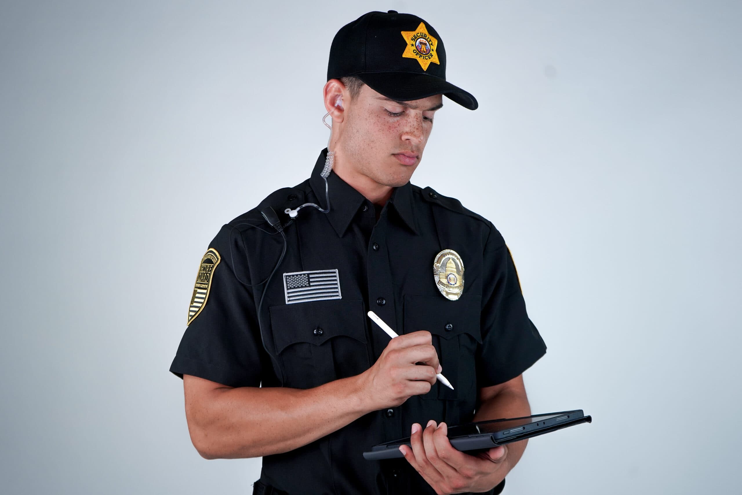 Security guard conducting a risk assessment using a tablet, identifying potential vulnerabilities in business security systems