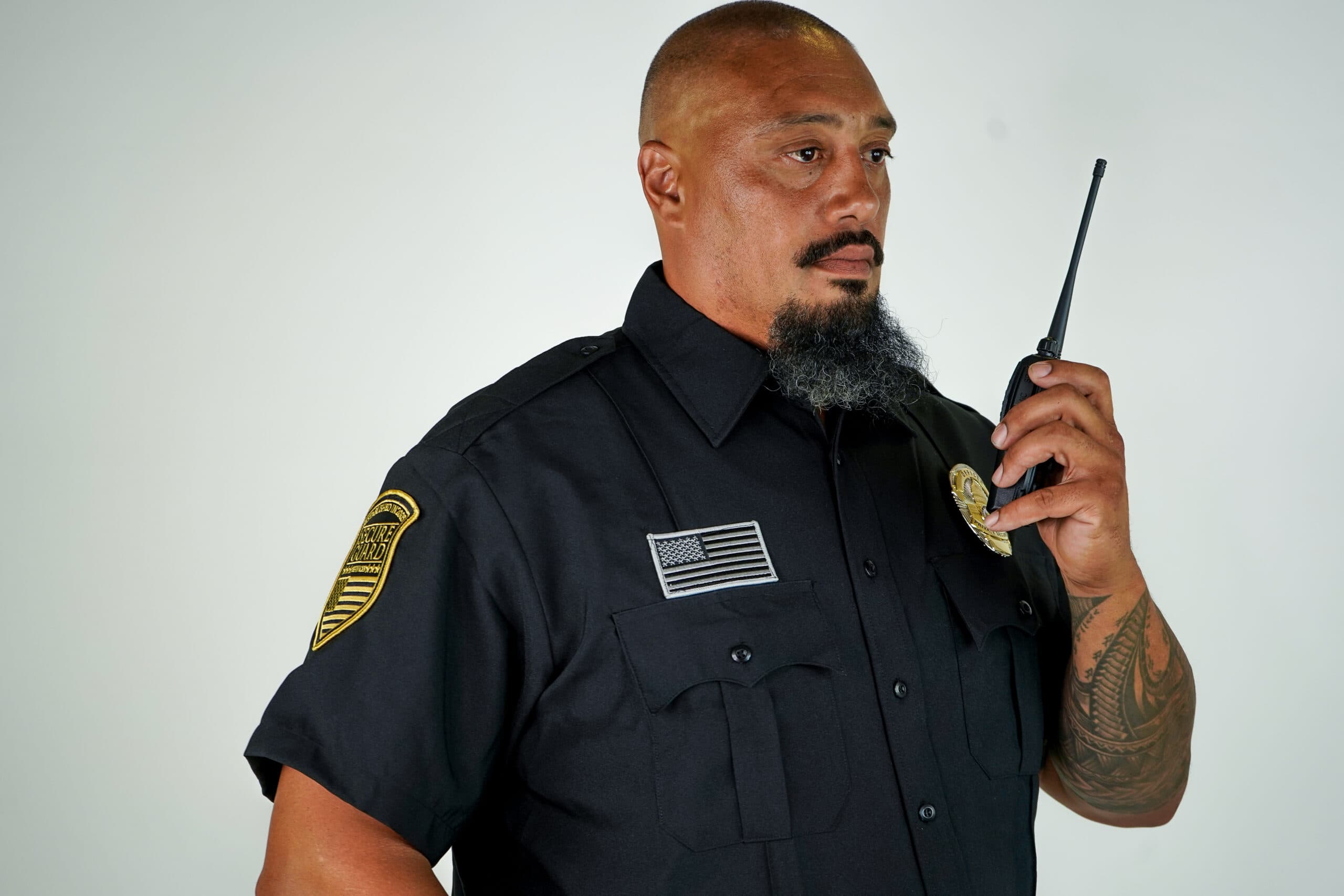 Professional security guard using two-way radio, representing trusted security guard services for businesses in Los Angeles